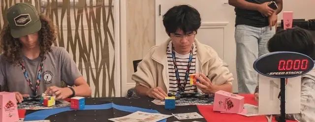 Two competitors solving puzzles at a cubing competition
